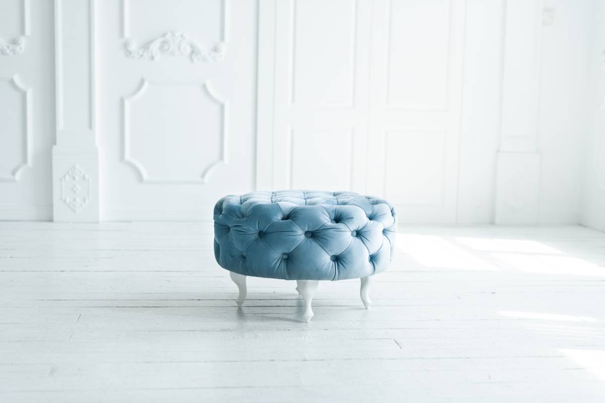 Blue poof ottoman in a room
